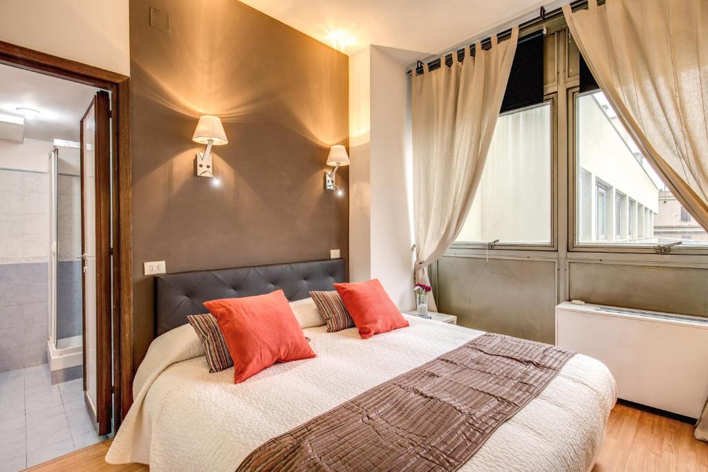a bedroom with a large bed with orange pillows at M&L Apartments - Ardesia Colosseo in Rome