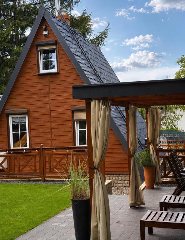 a house with a gambrel roof and a patio at Kamień na Kaszubach in Kamień