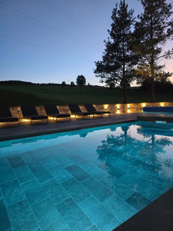 a swimming pool with lounge chairs and lights at Uvac lake "FF" in Sjenica