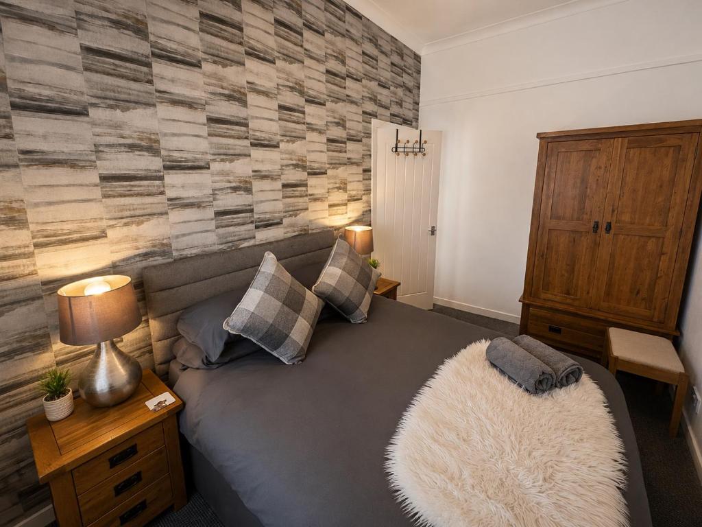 a living room with a gray couch with a rug at Hillhead Apartment in Coylton