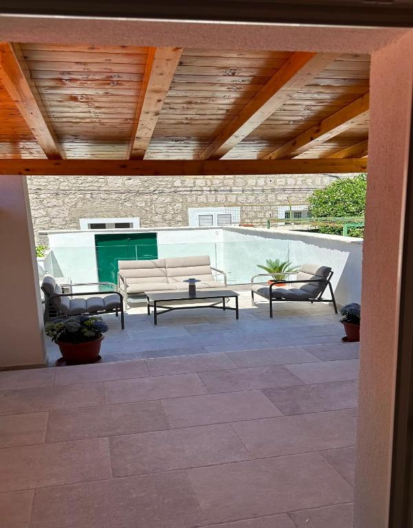 a patio with two chairs and a couch and a table at Apartment Dolce by DuBooker in Trpanj