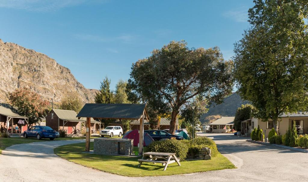 ein Park mit einer Bank neben einem Parkplatz in der Unterkunft Queenstown Top 10 Holiday Park in Queenstown