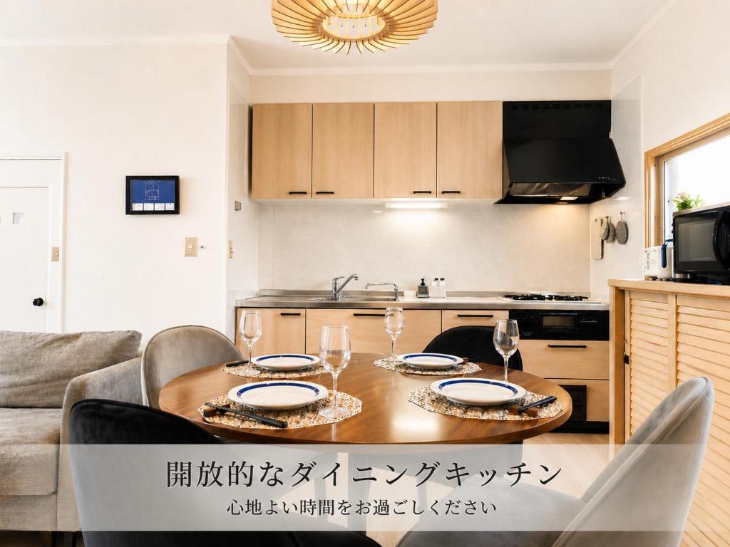 a kitchen with a table with glasses of wine at Prirate Villa Naru in Shiraoi