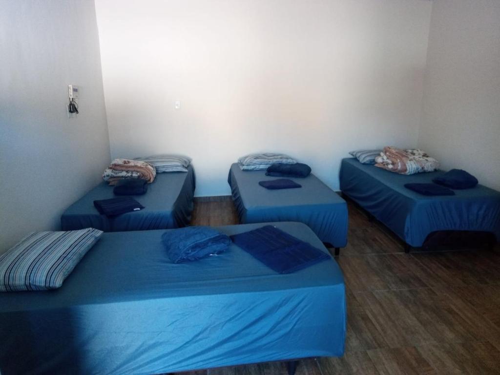 a room with four blue beds in a room at Pousada Paraíso in Telêmaco Borba