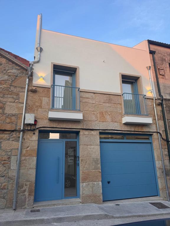 a building with two garage doors and two windows at Apartamentos Turísticos A Mariña Do Carril in Vilagarcia de Arousa