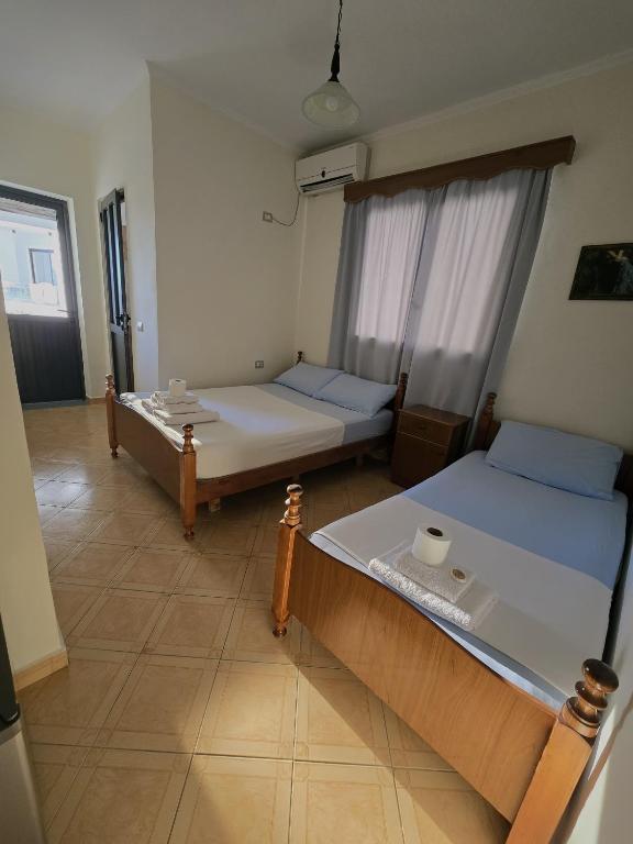 a room with two beds and a window at Onde Rooms in Vlorë