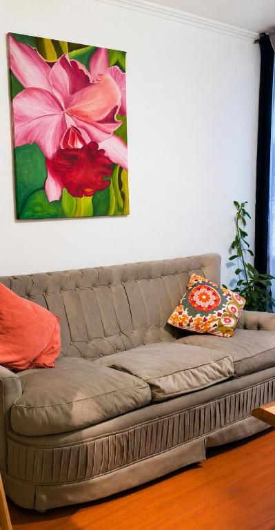 a couch in a living room with a painting on the wall at Acogedor departamento en La Serena in La Serena