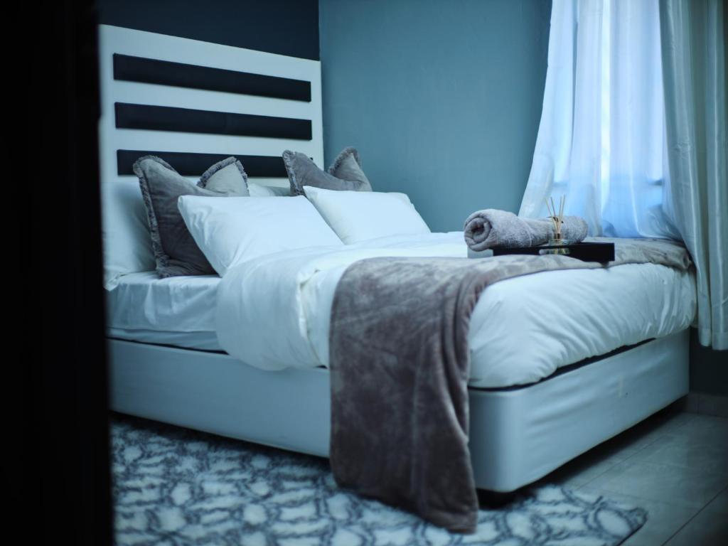 a bed with white sheets and pillows in a bedroom at P Daisy in Rundu