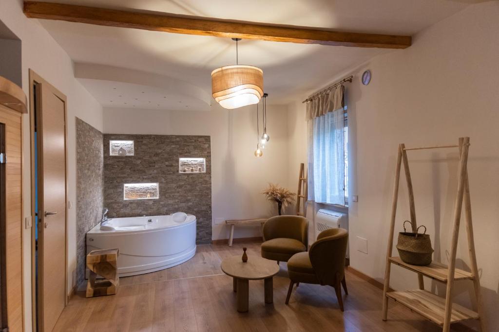 a bathroom with a tub and a chair and a table at Chiarelli Mountain Suite in Camigliatello Silano