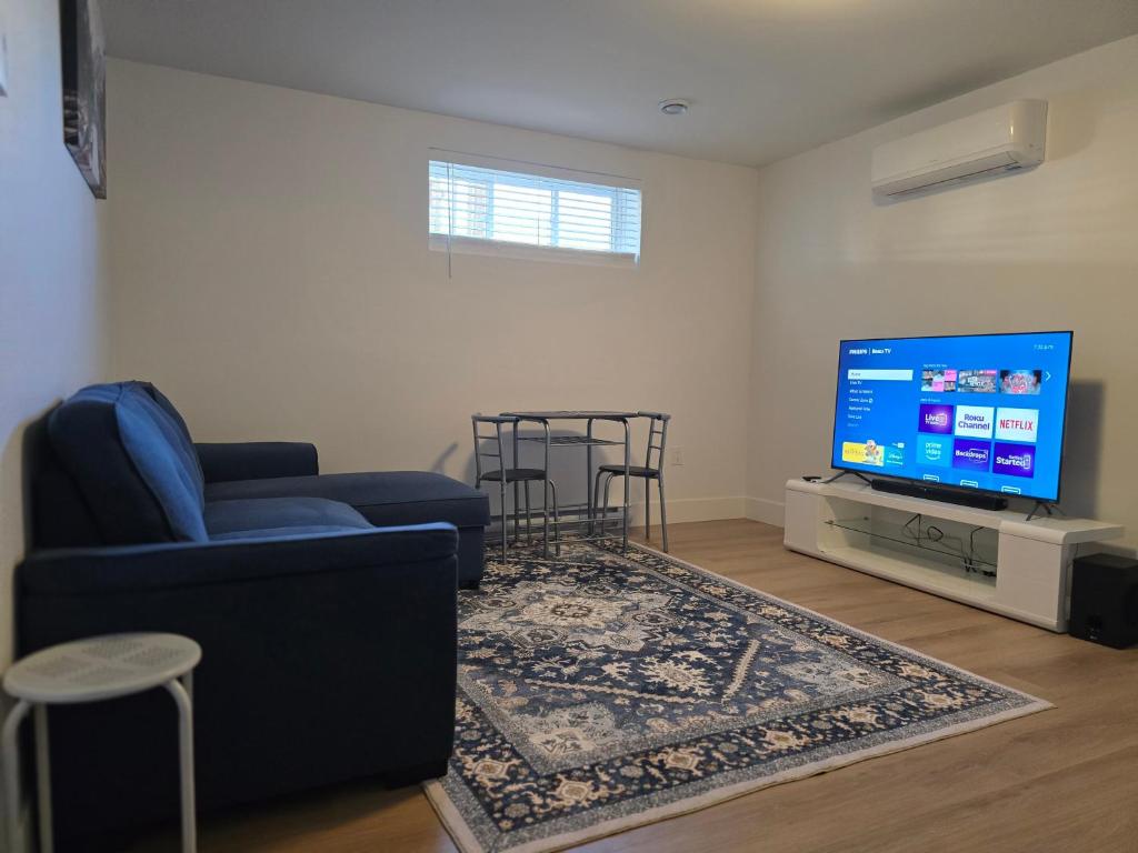 ein Wohnzimmer mit einer blauen Couch und einem Fernseher in der Unterkunft Light House in Riverview