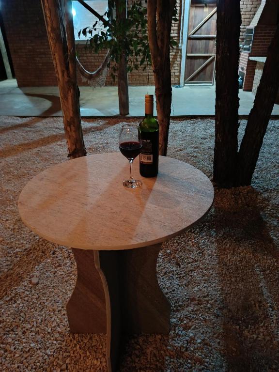 a table with a bottle of wine and a glass at Chalé Mandala de Pedra in São Thomé das Letras