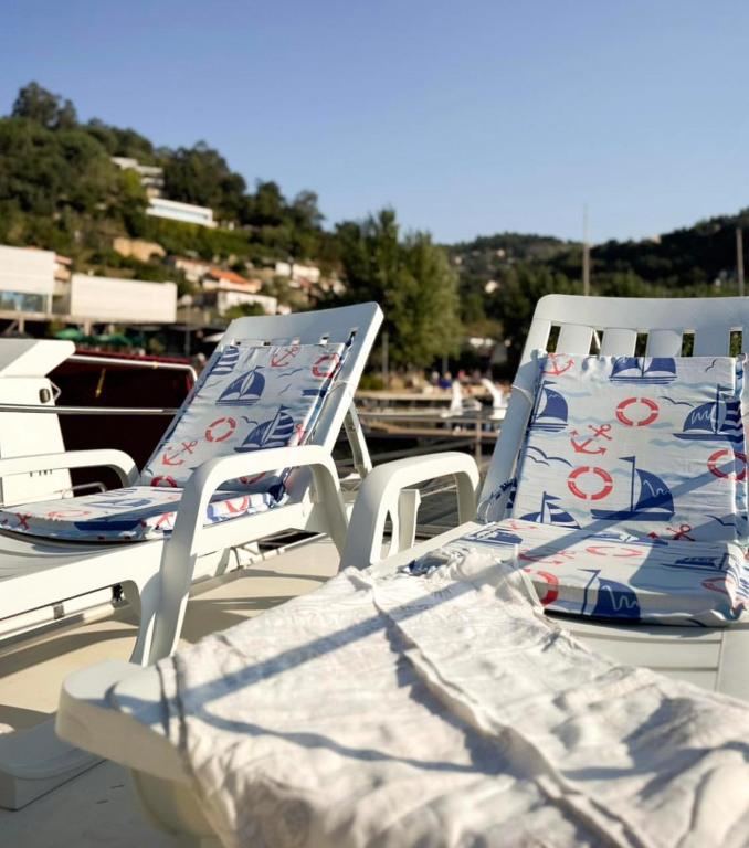 two lounge chairs sitting on top of a boat at Douro Houseboats in Várzea do Douro