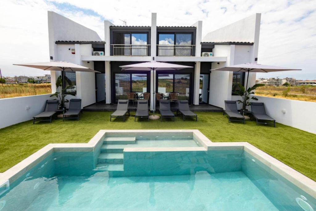 a villa with a swimming pool and a house at White Pampas Tiny houses in Paralia Dionysiou