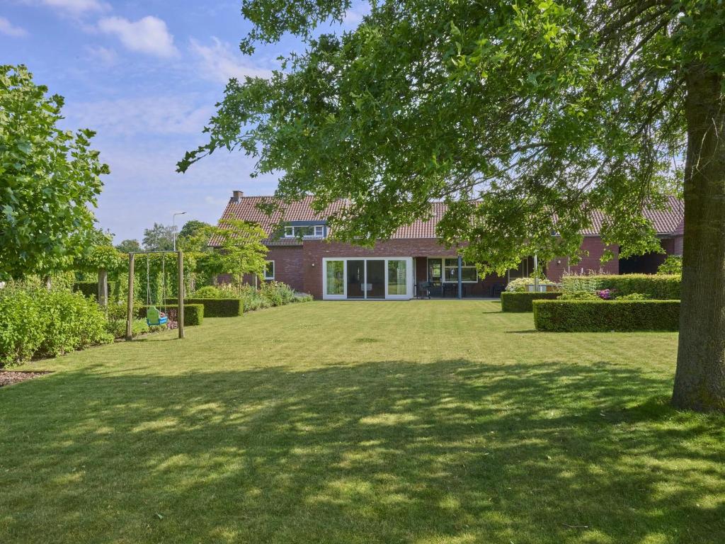 a large yard in front of a house with a tree at Laurahoeve in Nederweert