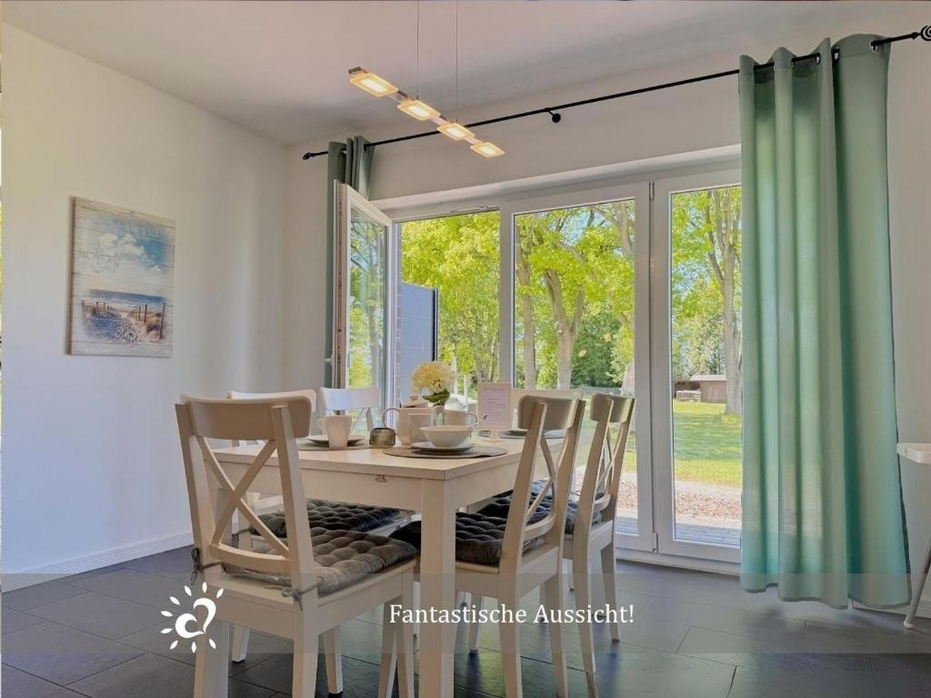 a dining room with a table and chairs and a window at Nordprinz mit Sauna und Whirlpool in Geestland