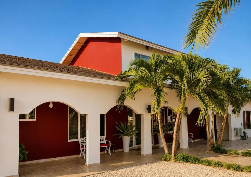 a house with palm trees in front of it at Ladybugs Apartments in Palm-Eagle Beach