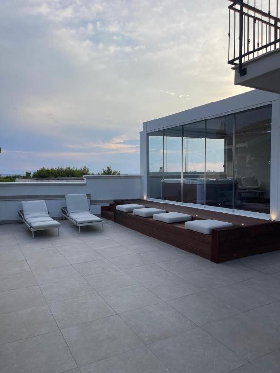 a balcony with two chairs and a building at Almaré Luxury Beach Apartments in Taranto