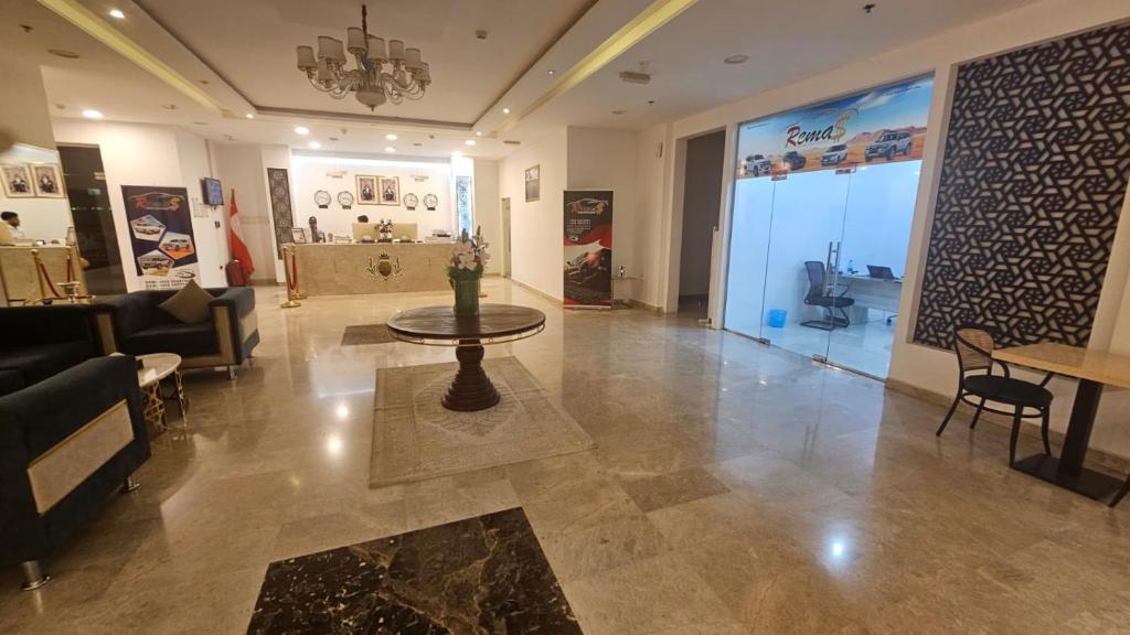 a living room with a table in the middle of a room at SR Hotel in Salalah
