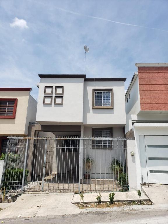 a white house with a fence in front of it at Casa completa con 3 habitaciones in Monterrey
