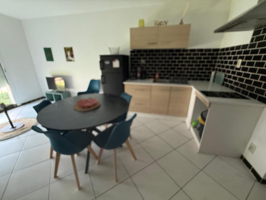 a kitchen with a table and chairs in a room at Petit nid chaleureux in Mimizan