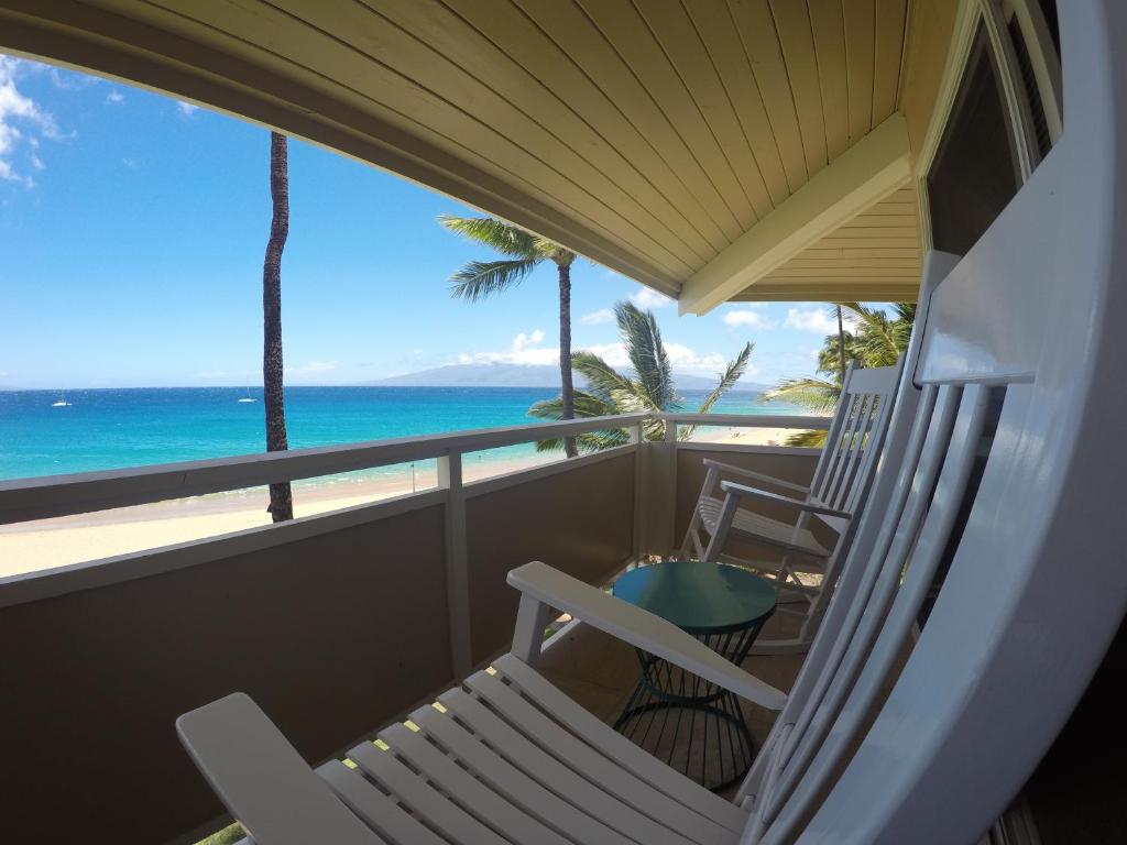 a balcony with a chair and a table and the ocean at Kaanapali Ocean Inn in Lahaina