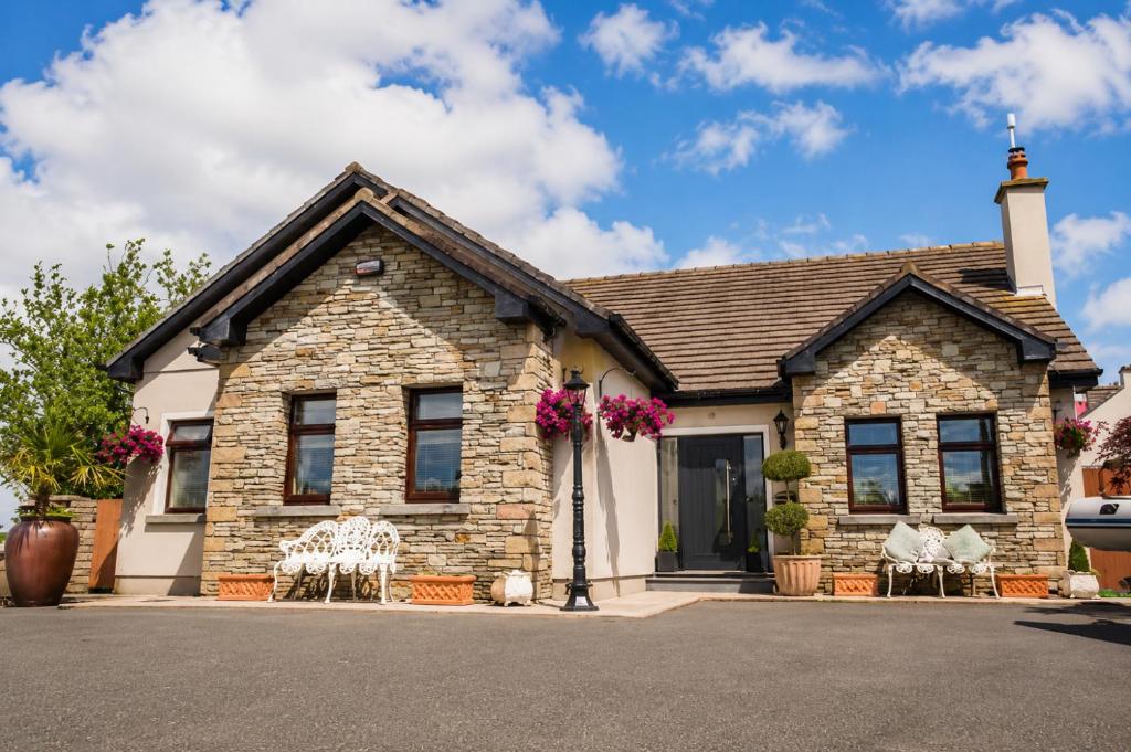 a stone house with chairs in front of it at Charlettes Lodge in Cobh