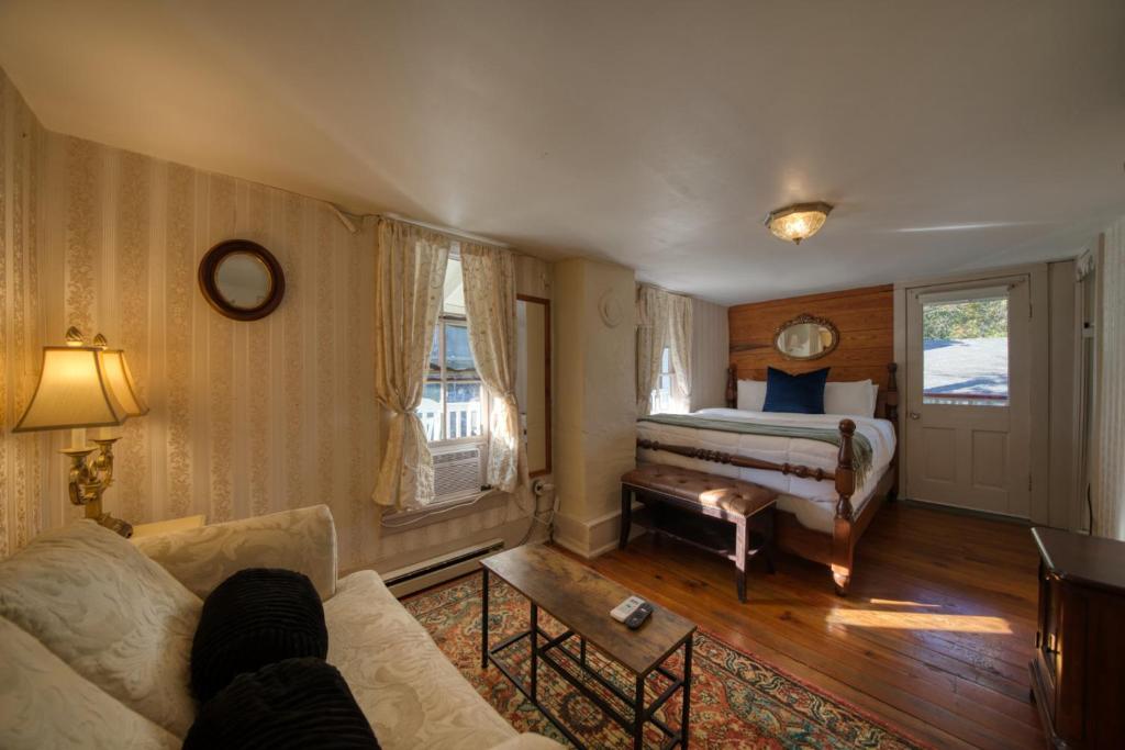 a living room with a bed and a couch at Downtown Four Poster Piedmont in Eureka Springs