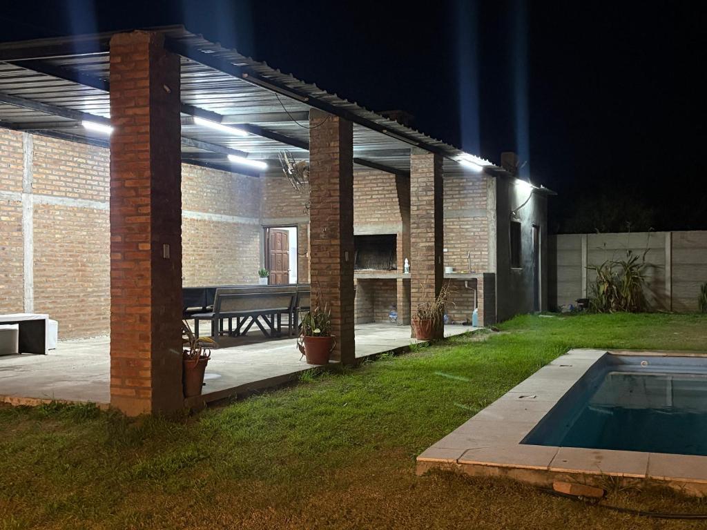 a patio with a table and a pool at night at Los Romanos farm in Sauce Bajada