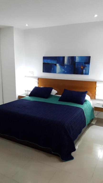 Un dormitorio con una gran cama azul con almohadas azules en Morros Epic Cartagena, en Cartagena de Indias