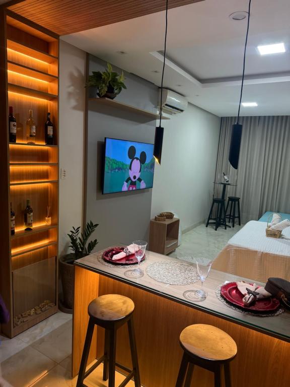 a kitchen with two stools and a counter top with a television at Ilha Bela Flat Alter do Chão in Santarém