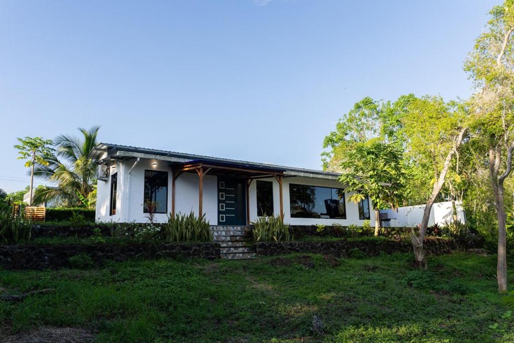 a white house with trees in front of it at Fernando's Bungalow in Puerto Ayora