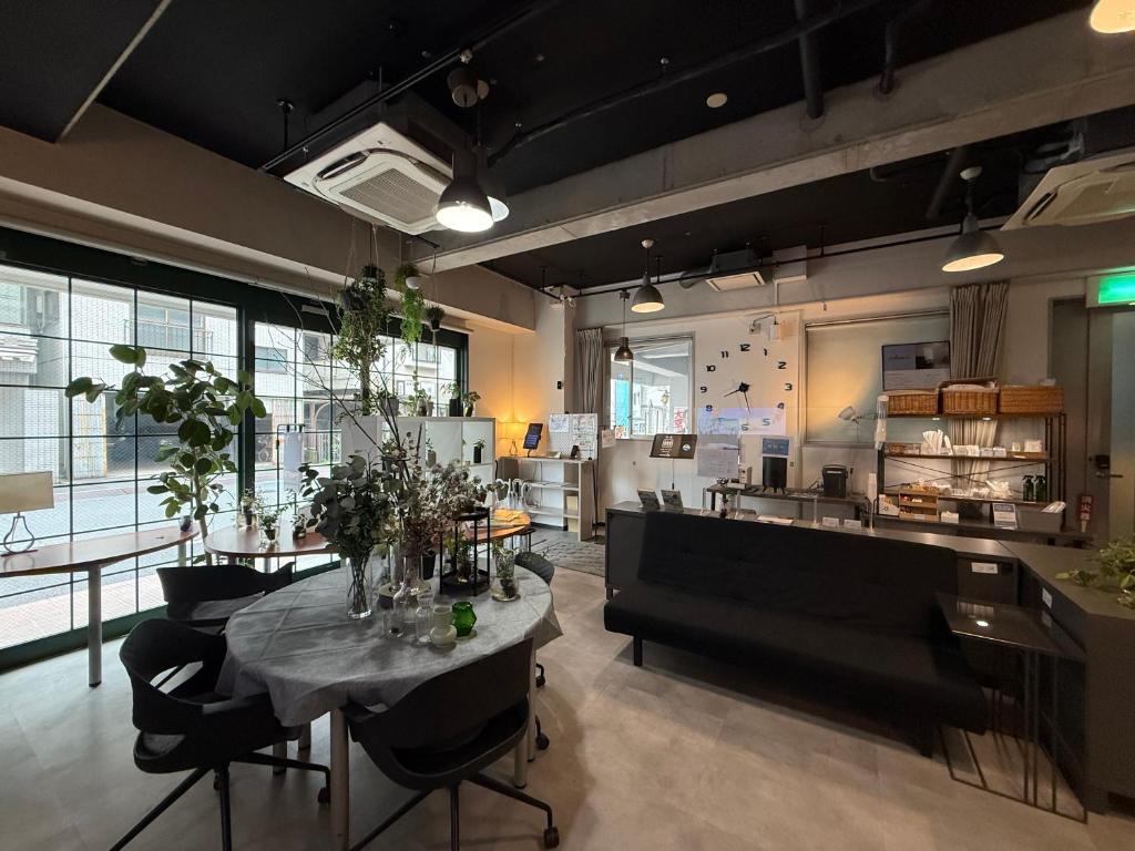 a room with a table and chairs and a kitchen at Business Hotel Legato in Tokyo