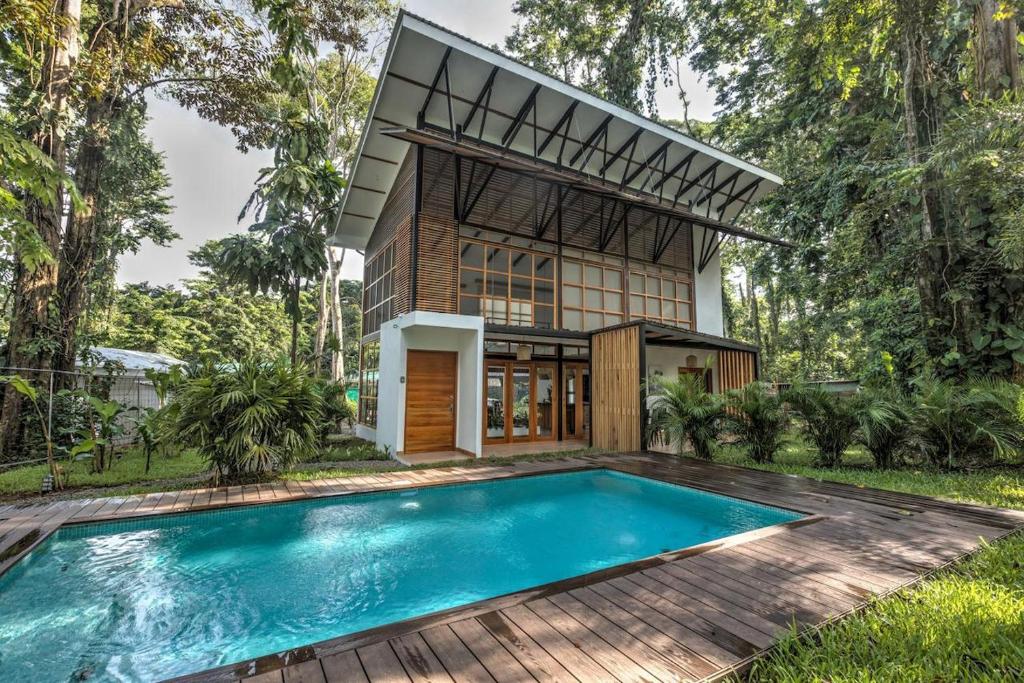 a house with a swimming pool in front of it at Porto Alegre Villas in Punta Uva