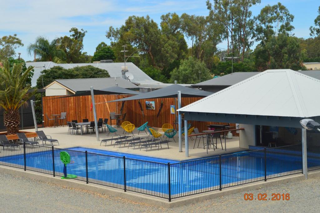 
a patio area with chairs, tables and umbrellas at Bundalong Villas in Bundalong
