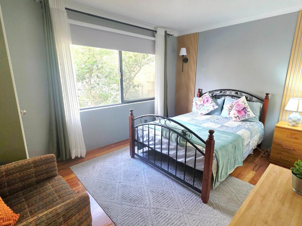 a bedroom with a bed and a large window at Homestay in Coogee