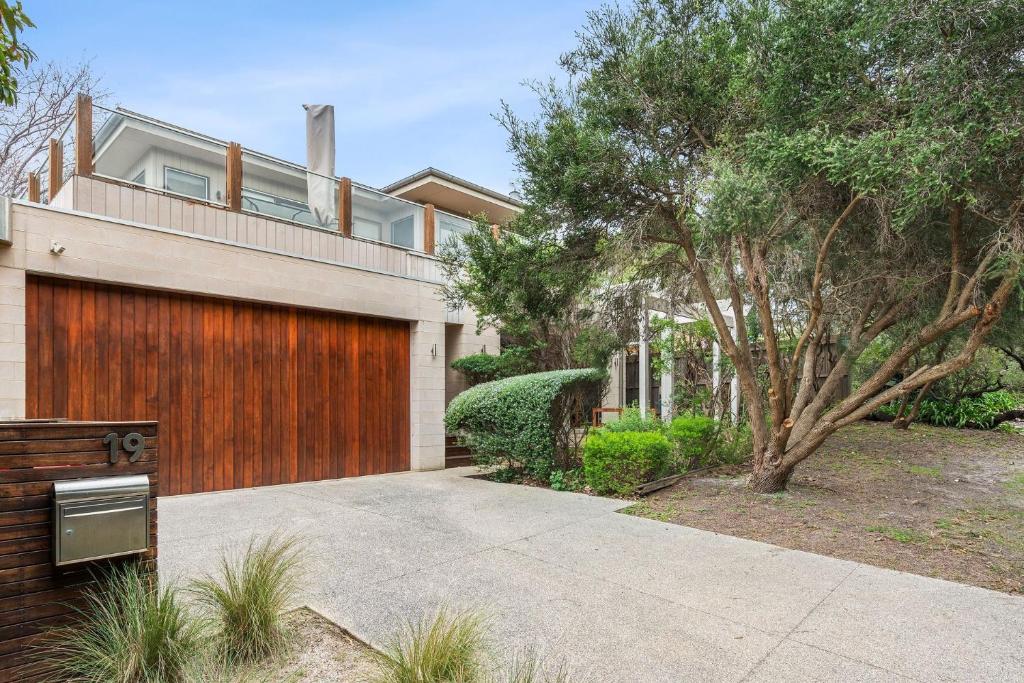 a house with a wooden fence and a driveway at 9 Doors From Front Beach in Point Lonsdale