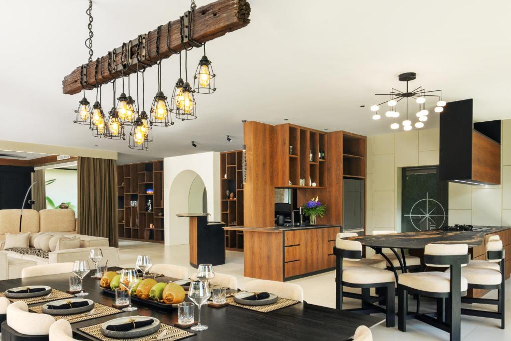a kitchen and living room with a table and chairs at Mandalore Villas Ubud - Adults Only in Ubud