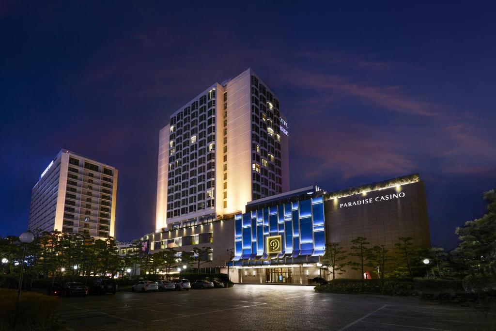um edifício alto com luzes azuis à noite em Paradise Hotel Busan em Busan