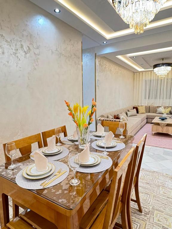 a dining room with a table with chairs and a couch at Dar marhaba in Tangier