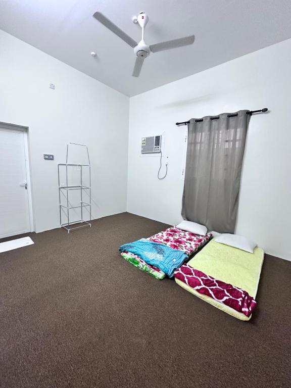 a room with two beds in a room with a ceiling at كوس الاشخرة in Al Sharqiyah