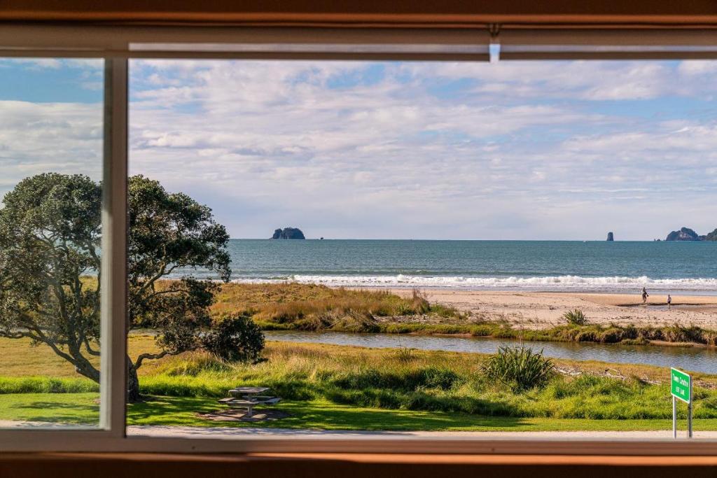 a view of the beach from a window at Seaview Studio Apartment - Beachfront with Heated Pool in Whitianga