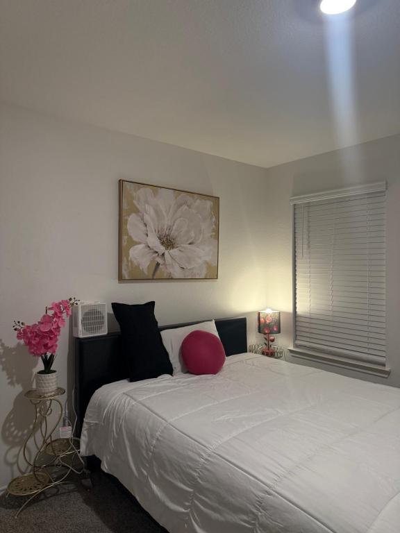 a bedroom with a white bed with a red pillow at Homely in Richmond