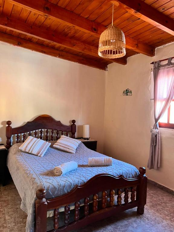 a bedroom with a bed with a blue comforter at Departamento Ayllu IV in Tilcara