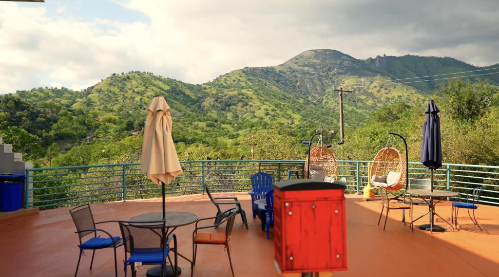a balcony with tables and chairs with mountains in the background at Sequoia Village in Three Rivers