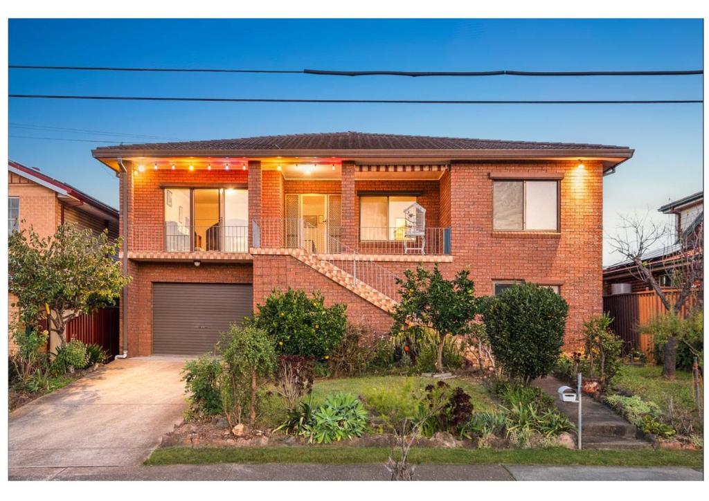 a red brick house with a garage at Kaban Power 11 in Marayong