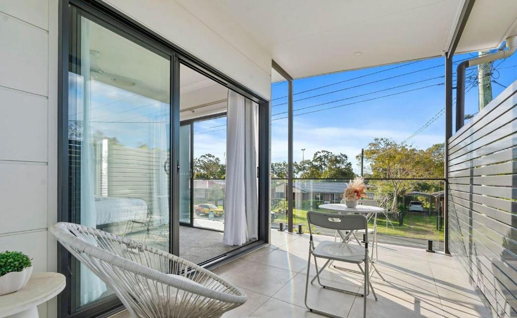 a room with a balcony with a chair and a table at Gemstone in Morayfield