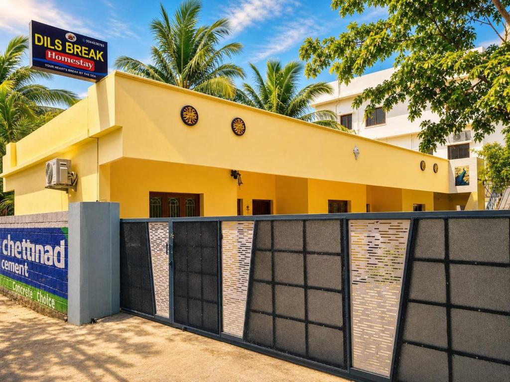 a yellow house with a gate in front of it at DilsBreak HomeStay in Kanyakumari
