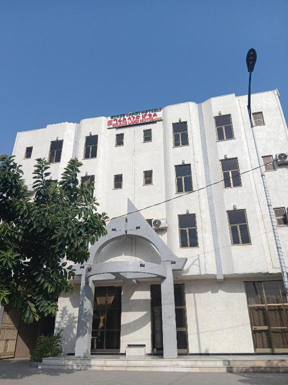 a white building with an arch in front of it at Grace Land Hotel - Awash in Āwash
