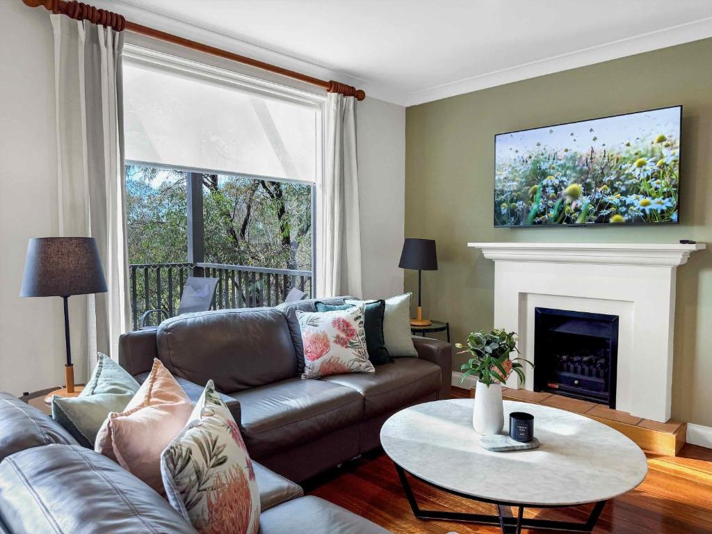 a living room with a couch and a fireplace at Vilamoura in Pokolbin