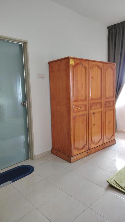 a wooden cabinet in a room with a window at Cahaya 382 in Sitiawan